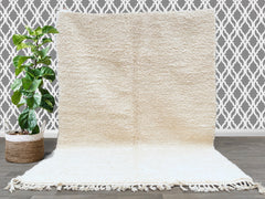 Elevate your home with this exquisite Moroccan Berber rug, a Beni Ouarain-style masterpiece in a pure ivory-white shade. Hand-knotted by skilled artisans, this high-pile shag rug (258 x 163 cm) is crafted from premium virgin wool, ensuring durability and plush comfort underfoot. The minimalist yet tribal design makes it a versatile addition to Scandinavian, bohemian, or contemporary interiors. Whether used as a statement living room rug, cozy bedroom carpet, or chic dining area accent, this authentic Berber
